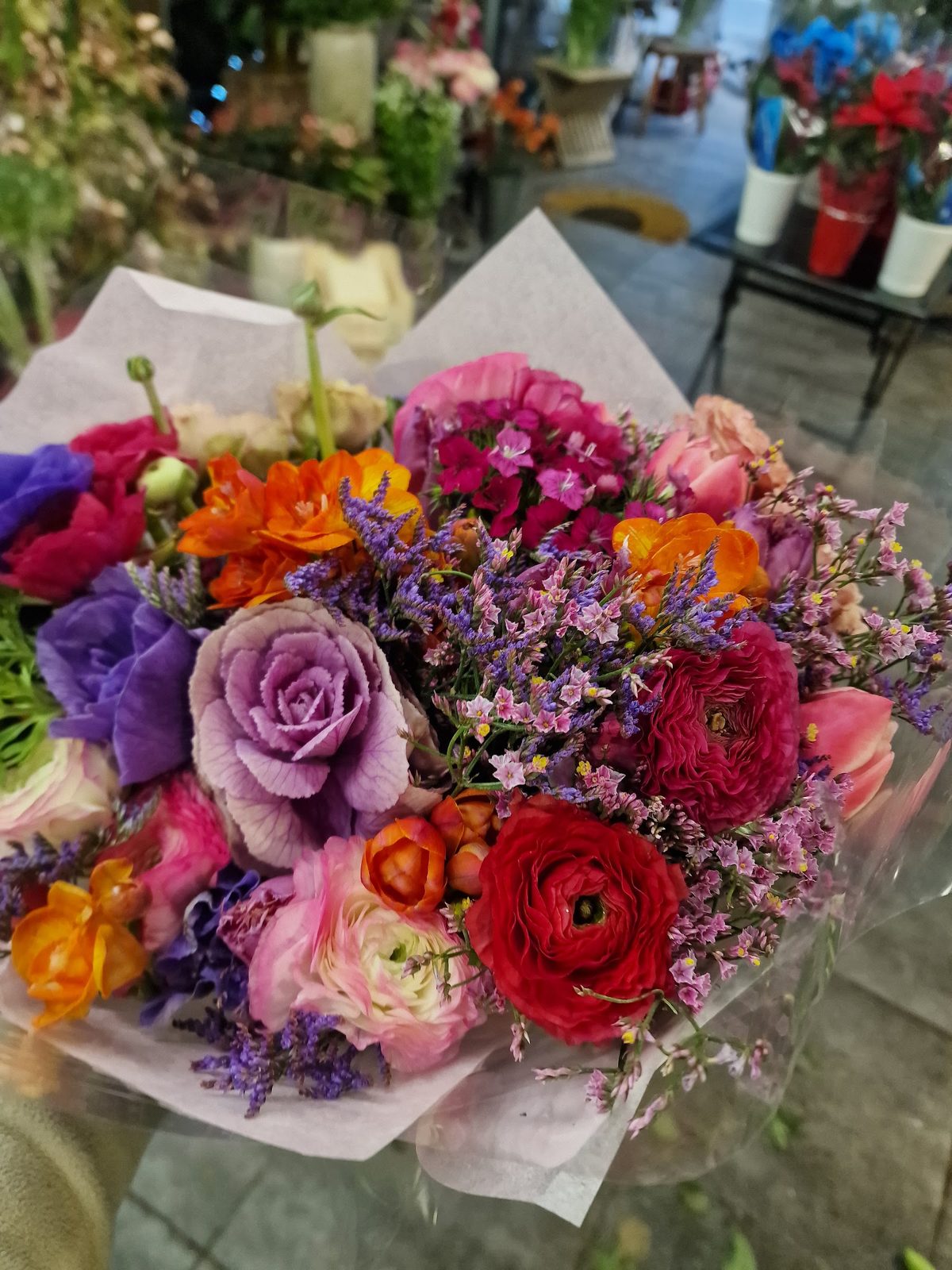 Bouquet coloré de renoncules, roses mauves et limonium